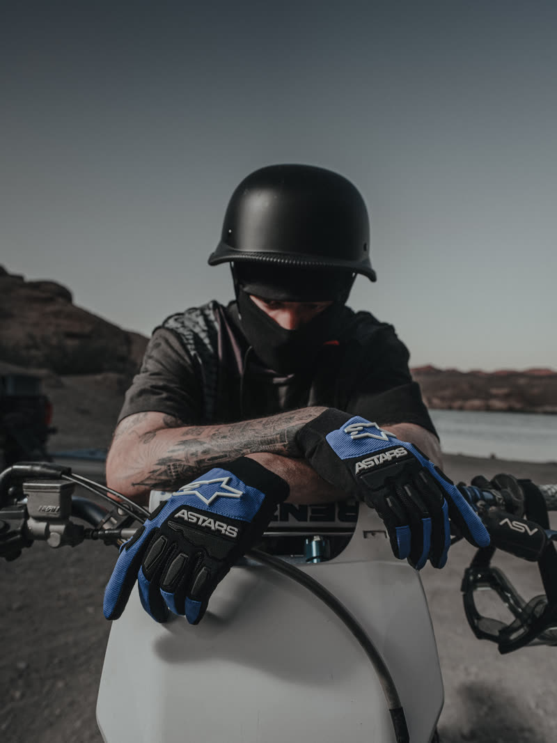 Leaning over the bars in the printed shirt and gloves