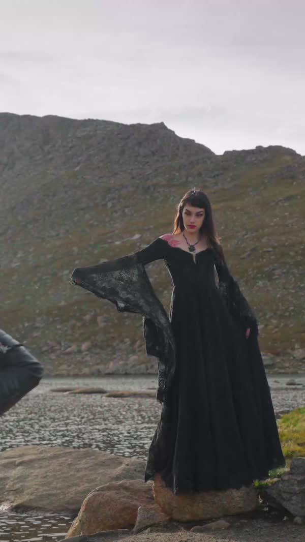 Black gown on the rocks above an alpine lake