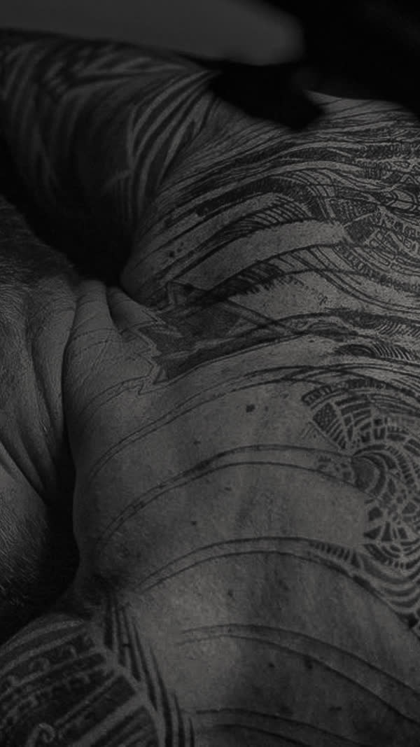 Ornamental blackwork across a back, close