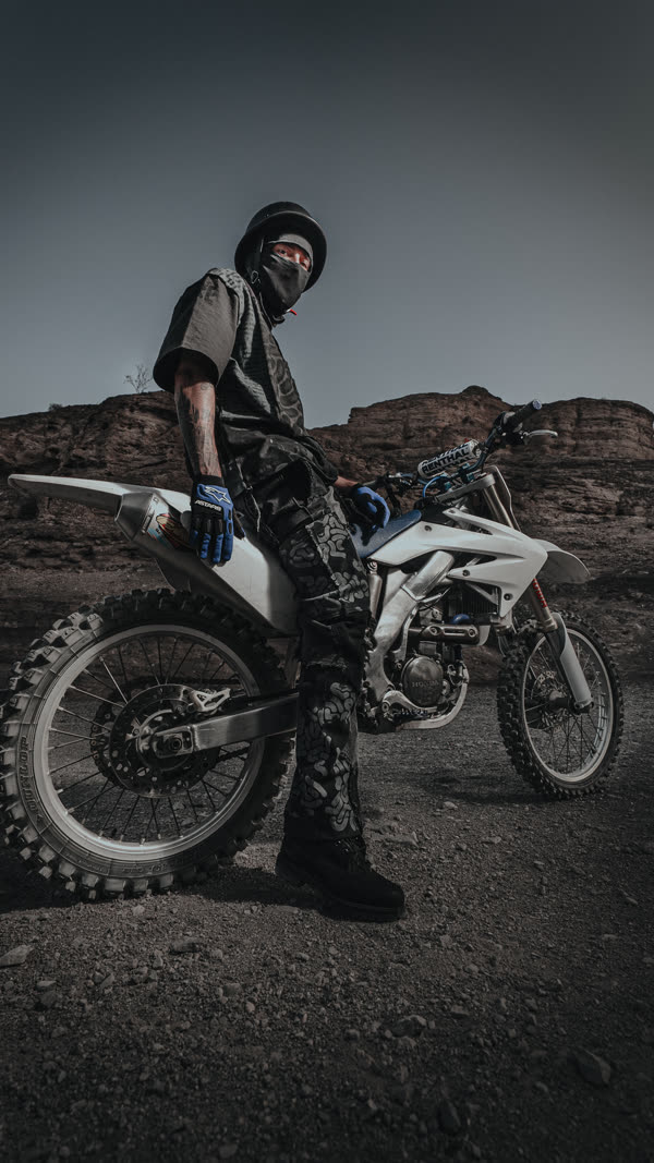 Rider on a dirt bike in the desert at last light